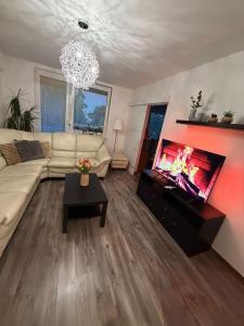 a living room with a couch and a flat screen tv at Ubytovanie u Tomáša in Nesvady