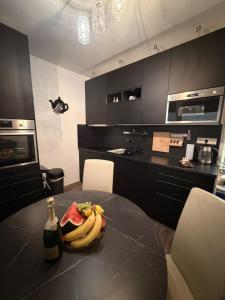 a table with a bottle of wine and a plate of bananas at Ubytovanie u Tomáša in Nesvady