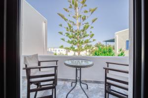 a glass table and two chairs on a balcony at Guesthouse Perdikouli in Aliki +51 photos