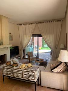 a living room with a couch and a table at Serene Villa with 4 Pools, Palmeraie, Marrakech in Douar Soukkane