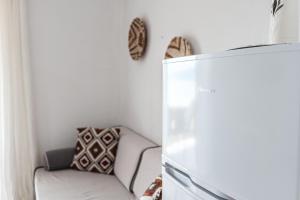 a living room with a couch and a refrigerator at Corfu Glyfada Beach Apartments in Glyfada