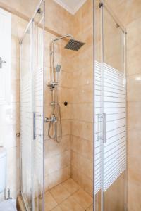 a shower stall with a glass door in a bathroom at Corfu Glyfada Beach Apartments in Glyfada