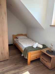 a bedroom with a bed and a wooden table at Wonderland Apartamenty in Bukowiec