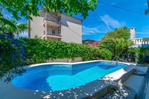 a swimming pool in front of a building at Apartments Adriatic Relax, heated pool, parking place in Duće
