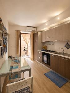 a kitchen with a table and a counter top at Carbonari Holiday House in Cefalù