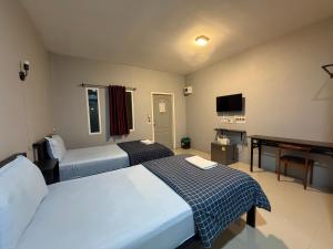 a hotel room with two beds and a television at เช็คอินรีสอร์ทชัยนาท Check-in resort in Ban Khao Khayai (1)