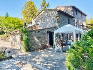 an old stone house with a tent in front of it at Tudesia Charming house in Todi