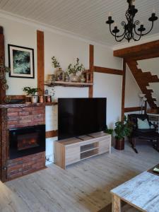 a living room with a flat screen tv and a fireplace at Timber loft in Vigra