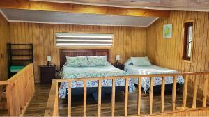 a bedroom with two beds in a wooden room at CostaLoft in Valdivia
