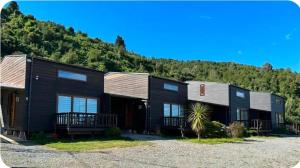 a black house with a mountain in the background at CostaLoft in Valdivia