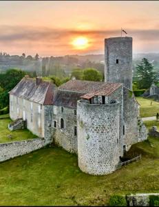 an old stone building with a sunset in the background at Château de Chalus-Chabrol in Châlus