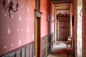 a hallway of an old house with a red wall at Château de Chalus-Chabrol in Châlus