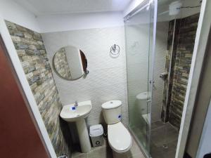 a bathroom with a toilet and a sink and a shower at Hotel El Empedrado in Popayan