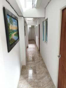 a corridor in a hospital with a painting on the wall at Hotel El Empedrado in Popayan
