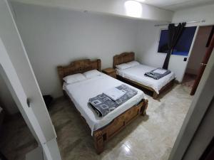 a bedroom with two beds in a room at Hotel El Empedrado in Popayan