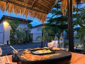 a table with a plate of food on a table at เช็คอินรีสอร์ทชัยนาท Check-in resort in Ban Khao Khayai (1)
