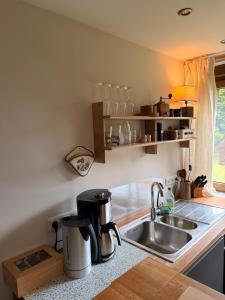 a kitchen with a sink and a coffee maker on a counter at Bisamlodge in Faßberg