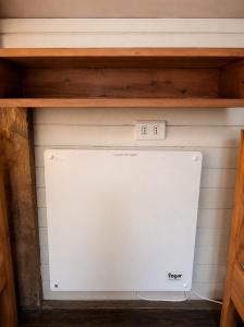 a shelf with a white appliance in a cabinet at Hostal Climb House in Puerto Varas
