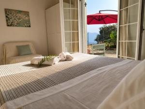 a bedroom with a large bed and an umbrella at Terra Saronia in Metamórfosis