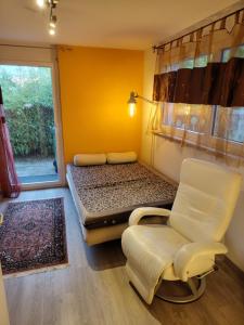 a room with a bed and a chair and a window at Zimmer oberhalb Kreuzlingen in Kreuzlingen