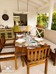 a dining room with a wooden table and chairs at Villa 300m from beach with shared swimming pool in Las Terrenas