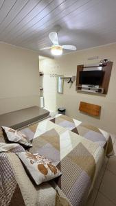 a bedroom with a bed and a flat screen tv at Pousada Recanto da Ana Alice in Abraão
