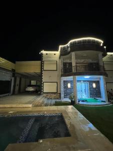 a large building with a swimming pool at night at فيلا في كينج مريوط in Alexandria