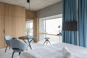 una camera da letto con un letto, un tavolo e delle sedie di Placid Hotel Design & Lifestyle Zurich a Zurigo