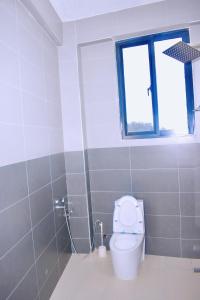 a bathroom with a toilet and a window at JG Luxury Hotel in Dodoma +11 photos