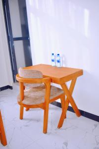 a wooden table with a chair and two bottles of water at JG Luxury Hotel in Dodoma