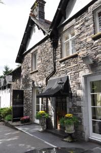 a stone building with a black awning in front of it at Beech Hill Hotel & Spa in Windermere +41 photos