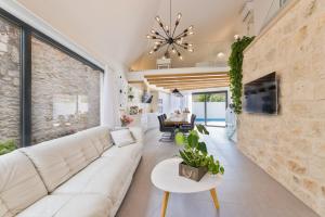 a living room with a white couch and a stone wall at VILLA STONE PEARL SUTIVAN - exceptional luxury new three-room villa - private pool and jacuzzi - perfect location right next to the town center and the beach - secured parking space in Sutivan