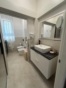 a bathroom with a sink and a toilet and a mirror at Chloè Vacanze in Iesi +30 photos