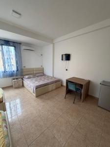 a bedroom with a bed and a table in it at Hotel Parking Pika in Shëngjin
