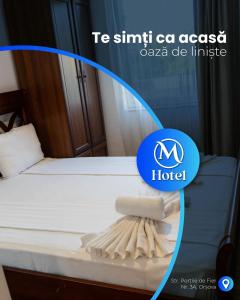 ein Bett in einem Zimmer mit einem Hotelschild daneben in der Unterkunft Hotel Manea Hub in Orşova