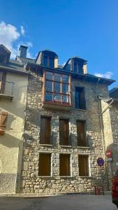 an old stone building with windows and a balcony at Casa Isabel, wifi y relax - Arafita Apartamentos in Sallent de Gállego +8 photos