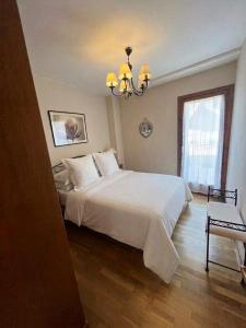 a bedroom with a large white bed and a chandelier at Casa Isabel, wifi y relax - Arafita Apartamentos in Sallent de Gállego