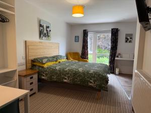 a bedroom with a bed and a window at Highermead House in Camelford