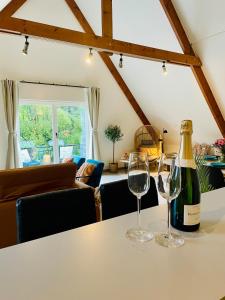 a bottle of wine and two glasses on a table at Villa Everbeur te Averbode in Scherpenheuvel-Zichem +11 photos