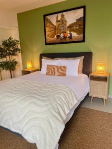 a bedroom with a large bed with two lamps at Villa Everbeur te Averbode in Scherpenheuvel-Zichem