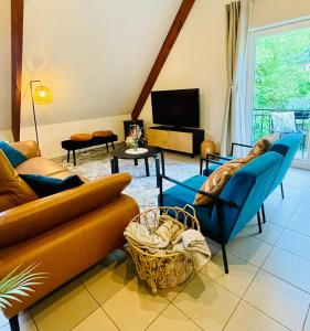 a living room with a couch and chairs and a tv at Villa Everbeur te Averbode in Scherpenheuvel-Zichem