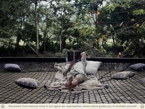 a woman laying on a blanket reading a book at Kantawa Refugio de Bienestar in El Zaino