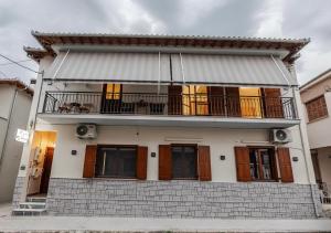 a large white house with a balcony on top at ZoYa`s Apartments in Agria
