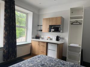 a small kitchen with a sink and a microwave at Highermead House in Camelford