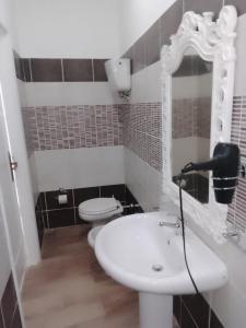 a bathroom with a white sink and a toilet at B&B Yle in Cetraro +1 photo