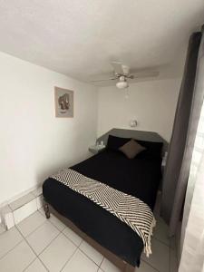 a bedroom with a black bed and a ceiling at Hotel Posada Jardín Aguascalientes in Aguascalientes