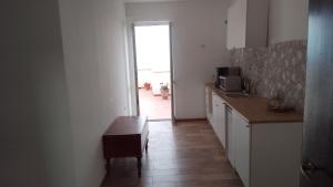 a kitchen with a table and a door to a hallway at B&B Yle in Cetraro