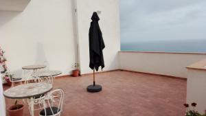 an umbrella in a room with two tables and chairs at B&B Yle in Cetraro