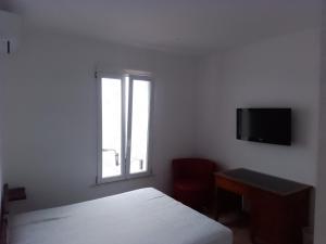 a white bedroom with a bed and a window at B&B Yle in Cetraro