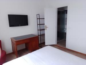 a room with a bed and a television and a table at B&B Yle in Cetraro